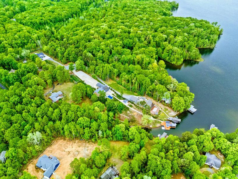 Aerial - Overhead view of the neighborhood docks and wooded lots along the shoreline.