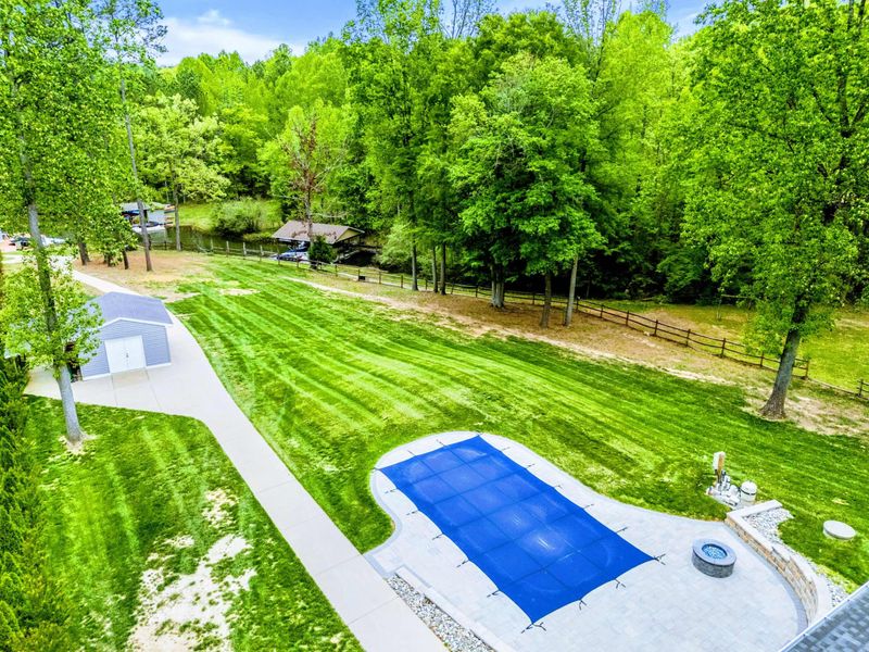 From Poolside to Pines – This yard doesn’t end with the patio—it opens into a whole world of green.