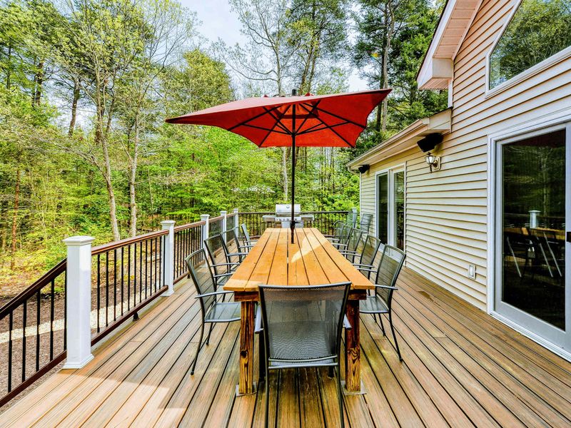 Deck - Dining table for eight with red umbrella and views into the tree canopy.