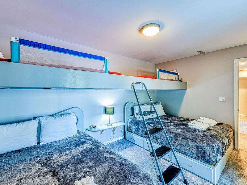 Bunk Room - Alternate showing three built-in bunk beds, ladder, and doorway to the hallway.