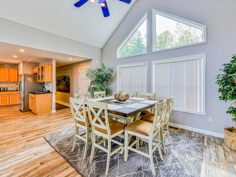 Dining Area - White X-back table for six beneath the vaulted ceiling and A-frame windows with blue ceiling fan.
