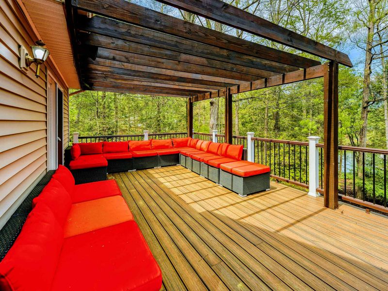 Deck Lounge - Alternate view of the deep red sectional seating under the pergola.