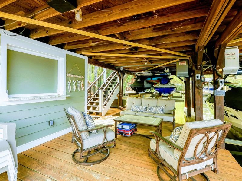 Lower Dock - Covered lounge area with cushioned seating, kayak and canoe storage, and lake breezes.