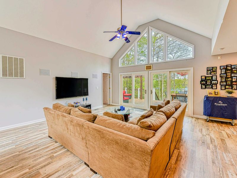 Living Room - Vaulted ceiling with TV, suede sectional, French doors to the deck, and photo gallery wall.