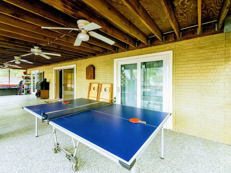 Screened Porch - Ping pong table with cornhole boards and French doors leading inside.
