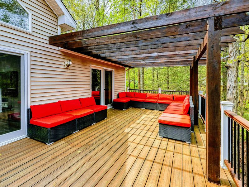Deck Lounge - Red outdoor sectional under the wood pergola for lakeside relaxation.