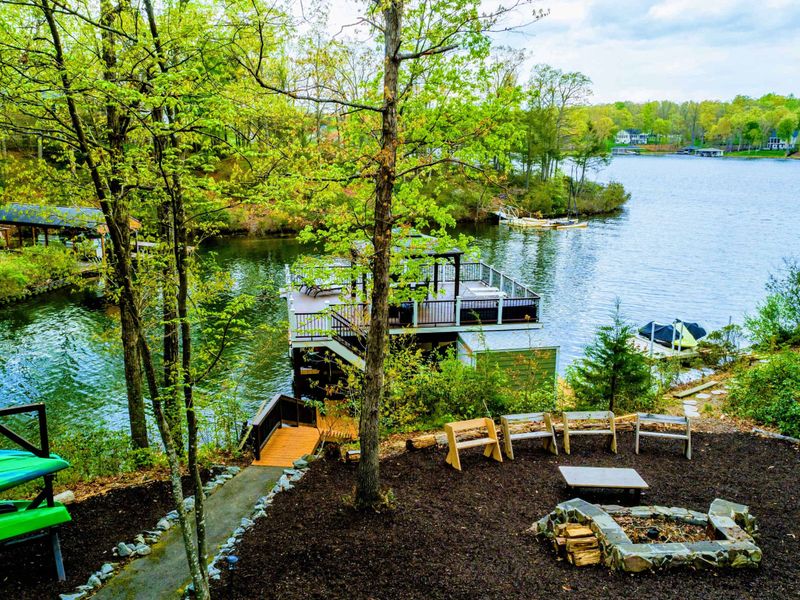 Waterfront - View from the upper deck of the stone fire pit, Adirondack benches, two-level dock, and Lake Anna cove.