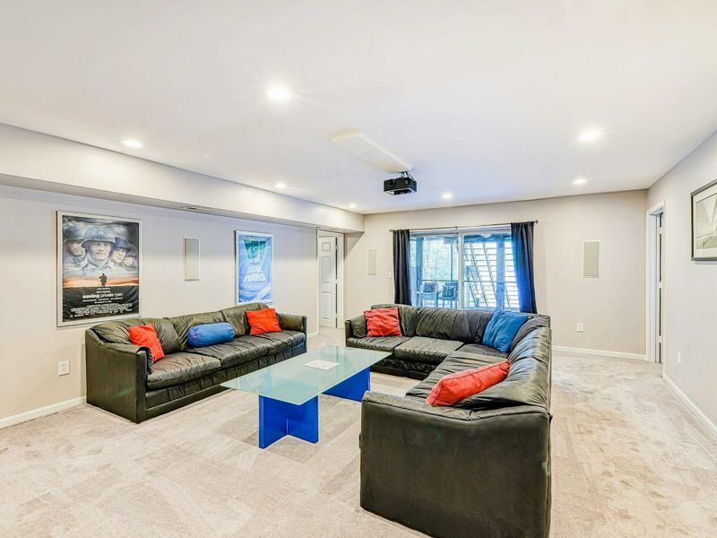 Home Theater - Reverse view showing the sectionals, ceiling projector, and sliding glass door to the yard.