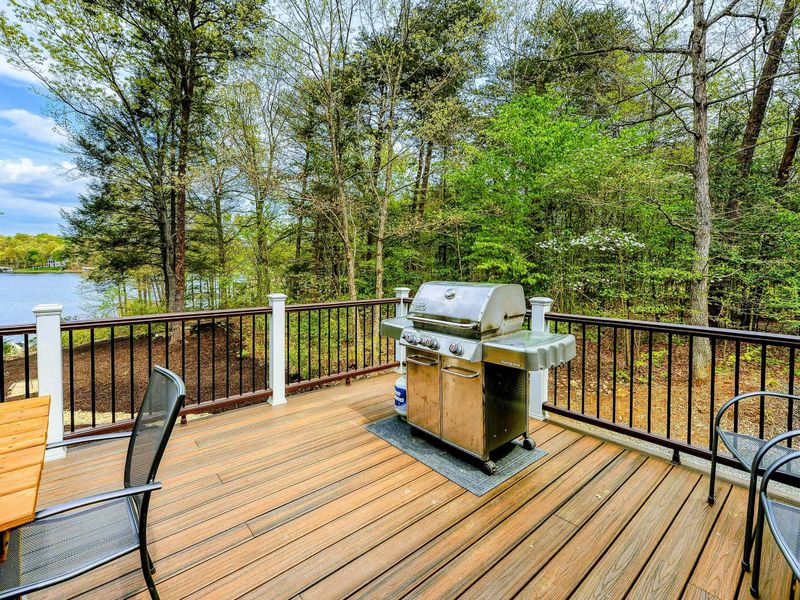 Deck - Stainless steel gas grill at the deck corner with lake views through the trees.