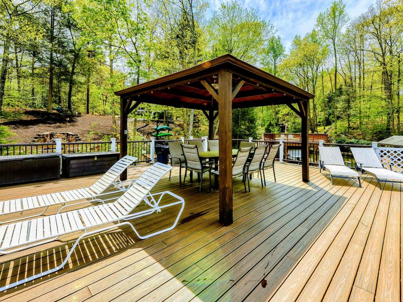 Dock Sundeck - Gazebo, lounge chairs, and gas grill with the fire pit and lake in the background.