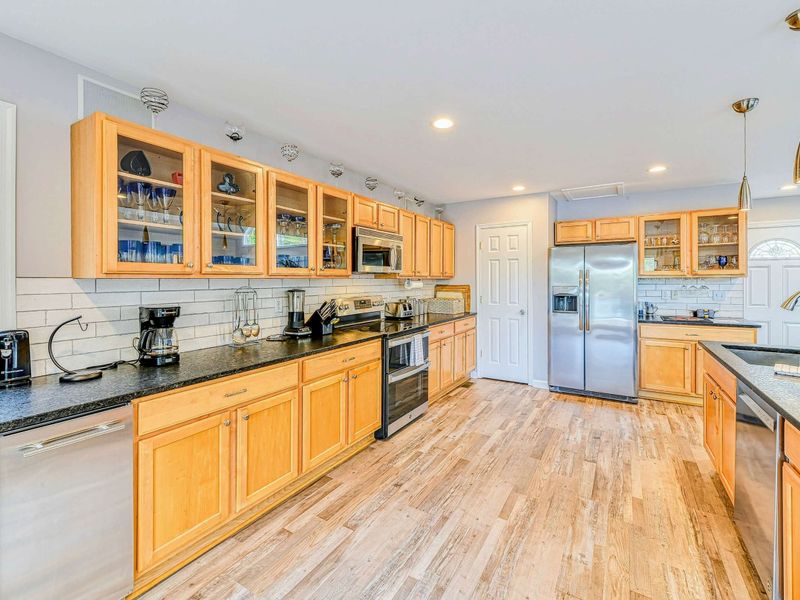 Kitchen - Maple cabinets with glass fronts, granite counters, subway tile backsplash, and stainless appliances.