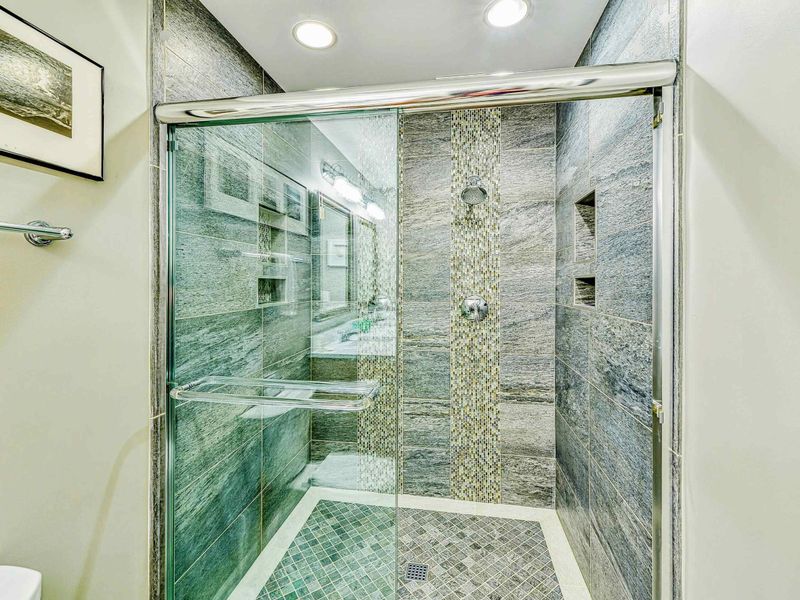 Lower Bathroom - Close-up of the slate tile walk-in shower with mosaic accent strip, glass enclosure, and built-in niches.