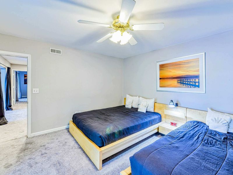 Bedroom 2 - Alternate angle showing the platform beds, sunset art, and doorway to the theater room.