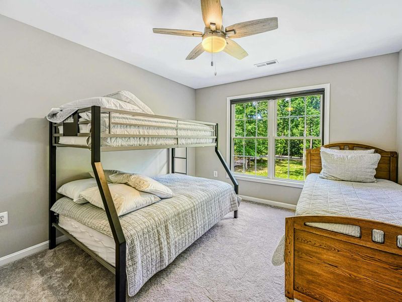 Bedroom 4 - Twin-over-full bunk bed with oak twin sleigh bed, ceiling fan, and garden-view window on the upper level.