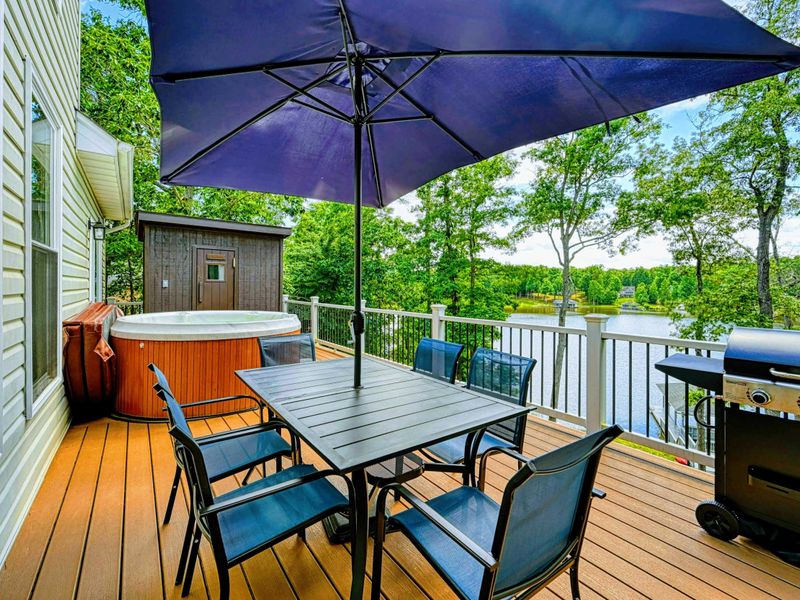 Dock - Covered dock with boat lift, sundeck, and gazebo on the quiet cove with canoe stored at the shore.