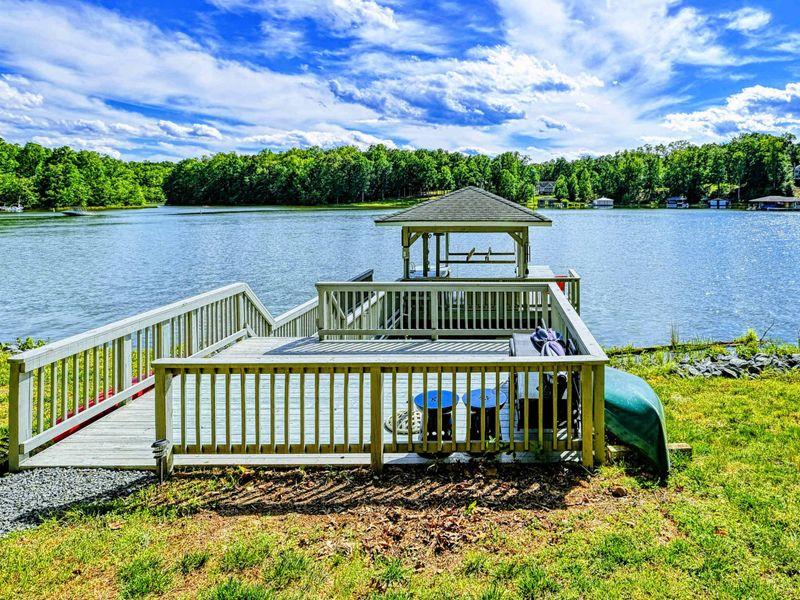 Dock - Covered dock with boat lift, sundeck, and gazebo on the quiet cove with canoe stored at the shore.