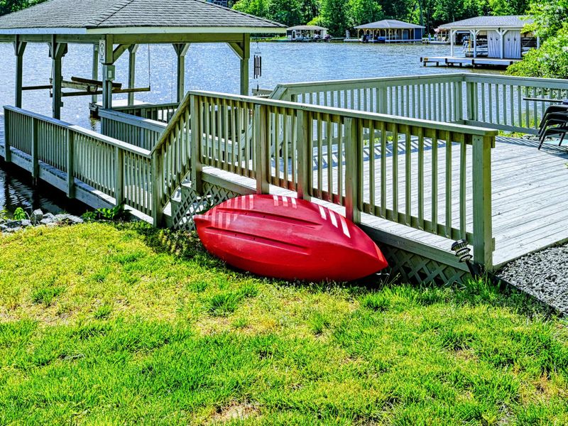 Waterfront - Red canoe stored beside the dock ramp with the covered gazebo and cove in the background.