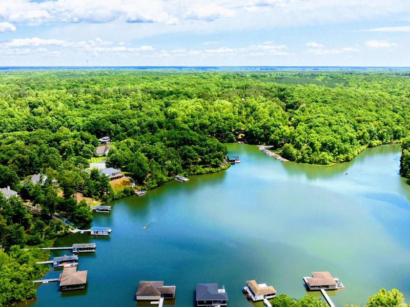 Aerial - Panoramic view of the Lake Anna cove with covered docks, boats, and wooded shoreline.