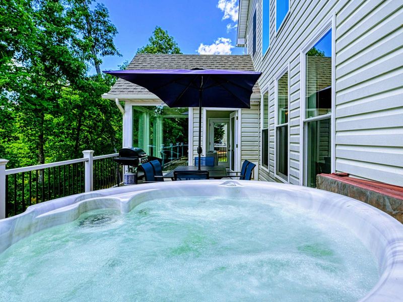 Hot Tub - Side deck hot tub with bistro seating, blue umbrella, and gas grill beside the sunroom entry.