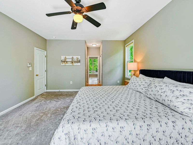 Primary Suite - Alternate showing the ceiling fan, en suite entry, closet, and leather accent chair.