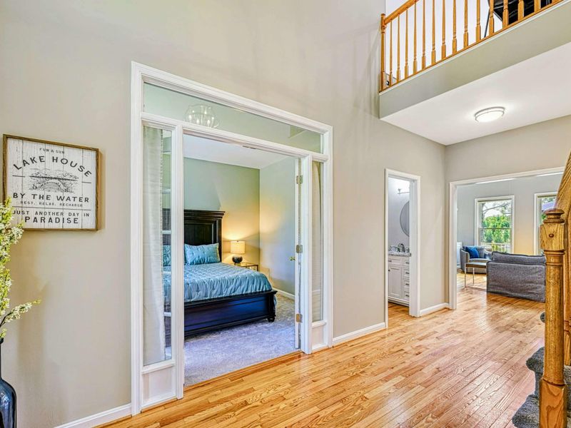 Foyer - View from the entry showing the main-level bedroom through French doors with the loft railing above.
