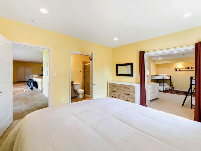 Queen Suite - From the bed, a view of the dresser, half bath access, and the curtained opening to the bunk room beyond.