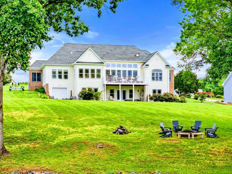 Lakeside Exterior - Brick accents, covered porches, and a wide lawn give the home a classic, welcoming look from the lake side.