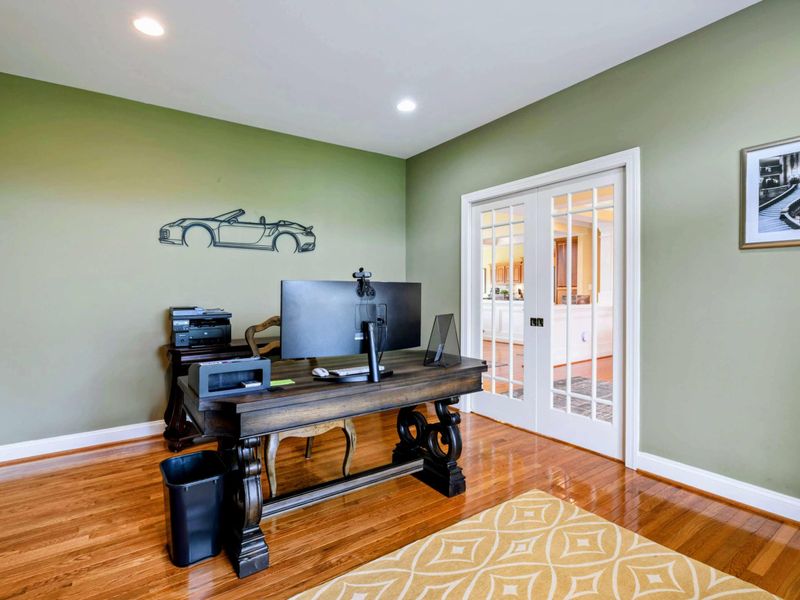 Home Office - French doors connect to the dining room, with wall art and plenty of space for remote work.