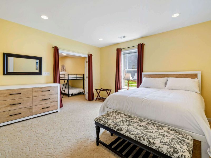 Queen Suite with Bunk Access - A queen bed with a toile bench sits just steps from the adjoining bunk room through a curtained opening.