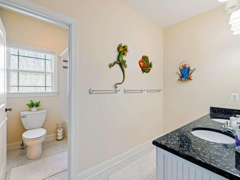 Shared Bath - A privacy window and whimsical frog and fish decor keep things fun in this full bath shared between lower-level bedrooms.