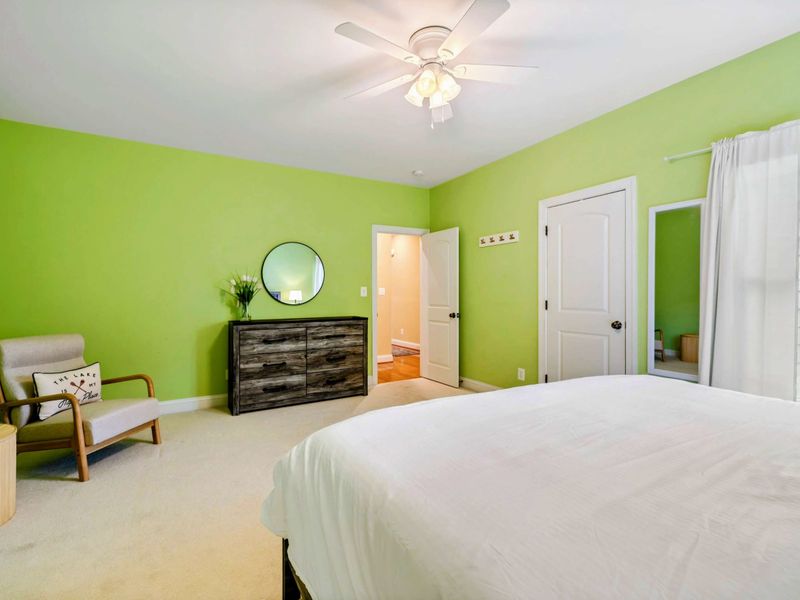 King Bedroom - The dresser, accent chair, and doorways to the closet and hallway, with a "Lake is My Happy Place" pillow.