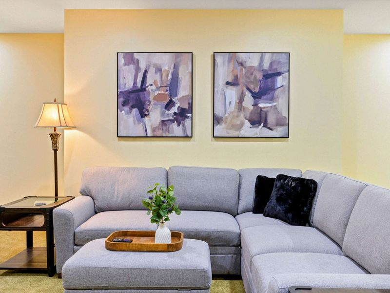 Game Room Detail - Abstract art and a plush sectional with an ottoman create a cozy spot to unwind after a day on the lake.