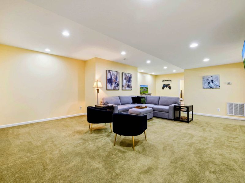 Game Room - A large sectional, accent chairs, and a wall-mounted Smart TV make this the lower-level hangout for movie nights and gaming.
