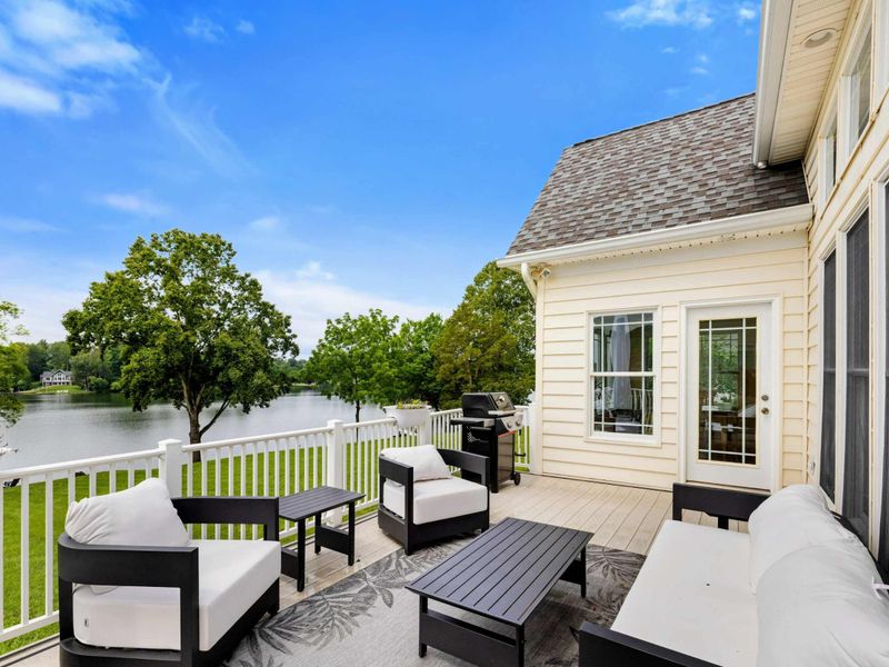 Deck Lake View - The outdoor seating area looking directly toward the lake, with the shoreline and dock in the distance.