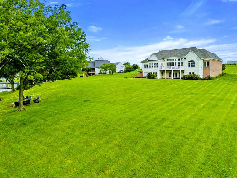 Aerial Side View - From above, the property reveals its scale, with a spacious yard stretching down to the lake.
