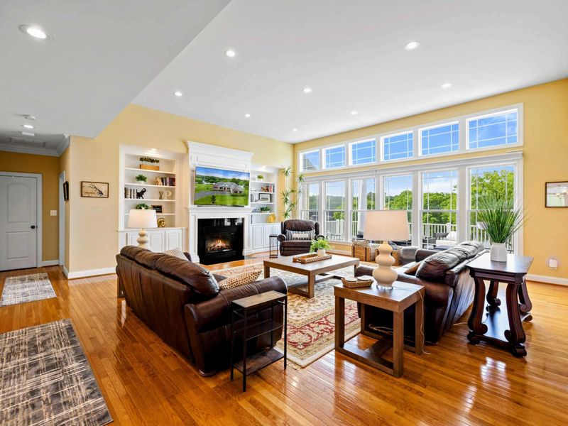 Great Room - A wider view showing the vaulted ceiling, fireplace wall, and floor-to-ceiling windows that flood the room with light.