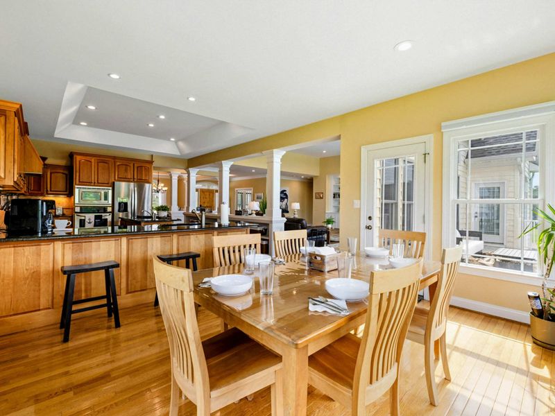 Breakfast Nook - A sunlit dining table set for six sits just off the kitchen, with the great room flowing beyond.