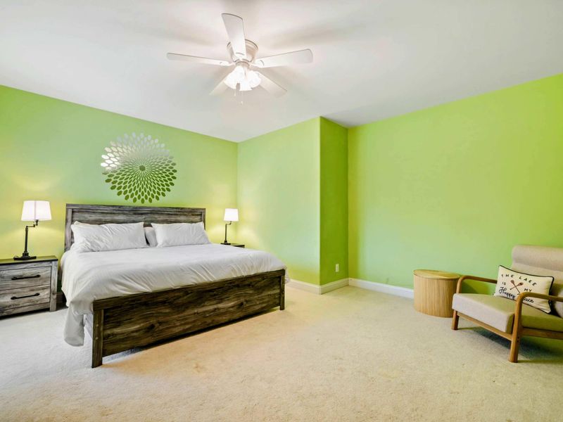 King Bedroom - A wider angle showing the ceiling fan, reading chair, and plenty of room to spread out.