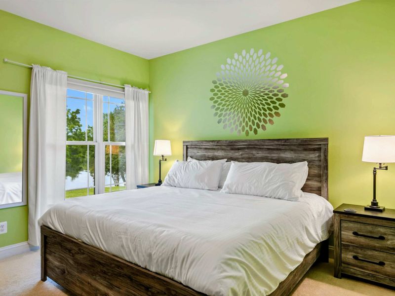 King Bedroom - Bright green walls, a rustic wood king bed, and lake views through the window give this room a cheerful, energetic feel.