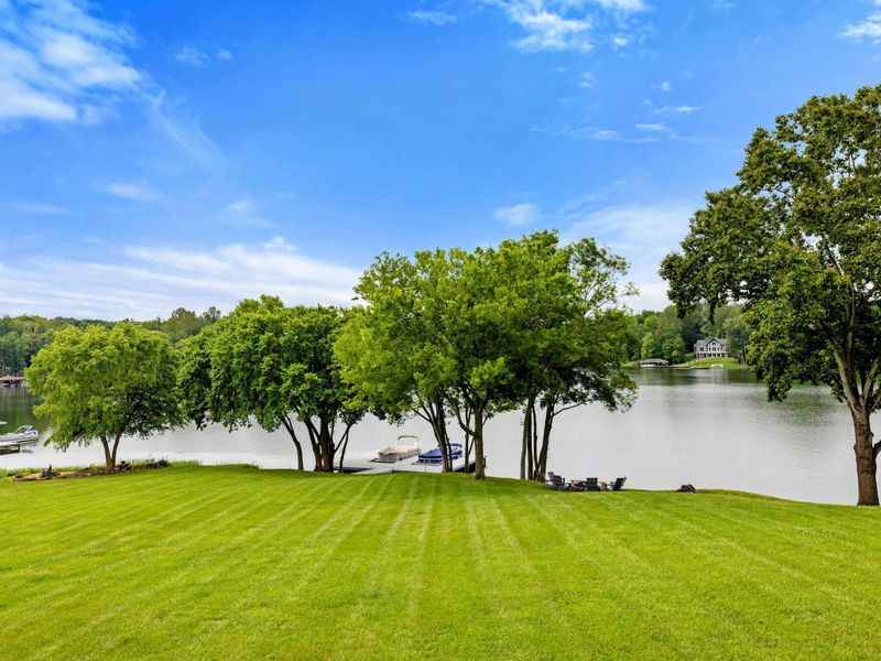 Lake Panorama - The sweeping view from the deck across the lawn, through the shade trees, and out to the open lake.