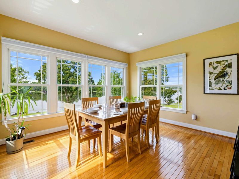 Dining Nook - A second angle showing the lake views through corner windows, with the deck and lawn just outside.