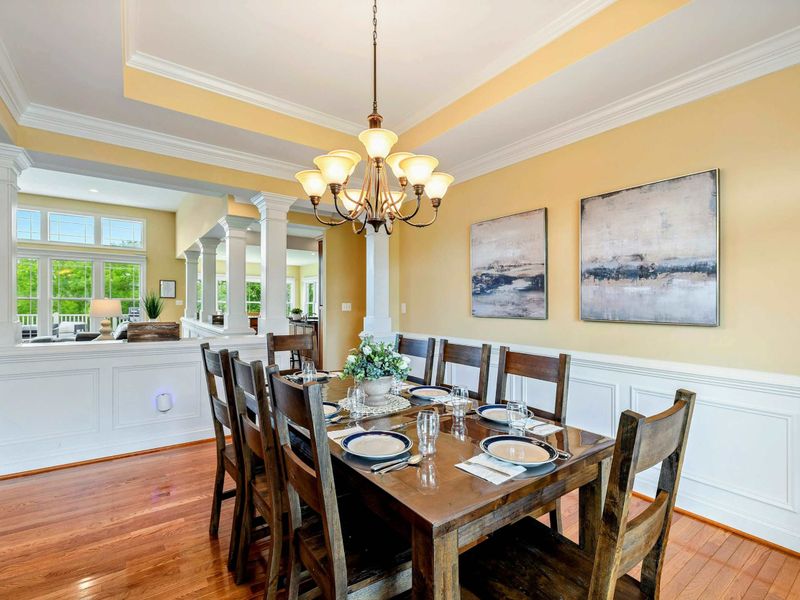 Formal Dining - Another angle showing the table set for a full group, with art, warm tones, and elegant crown molding.