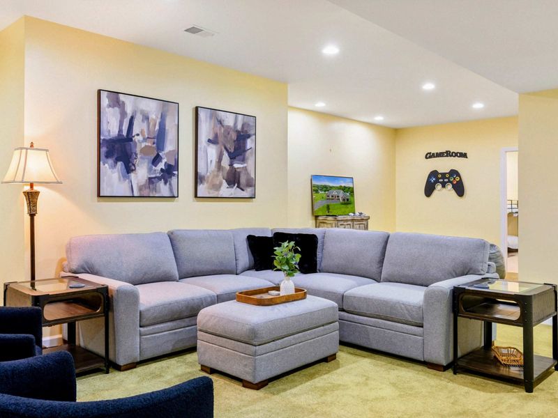 Game Room Seating - A closer look at the comfortable sectional and abstract art, with a "Game Room" controller sign on the wall.