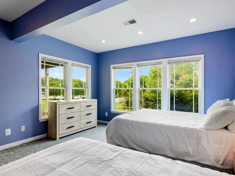 Double Queen Bedroom - The tray ceiling and green views through the windows bring a bright, airy feel to this generously sized room.