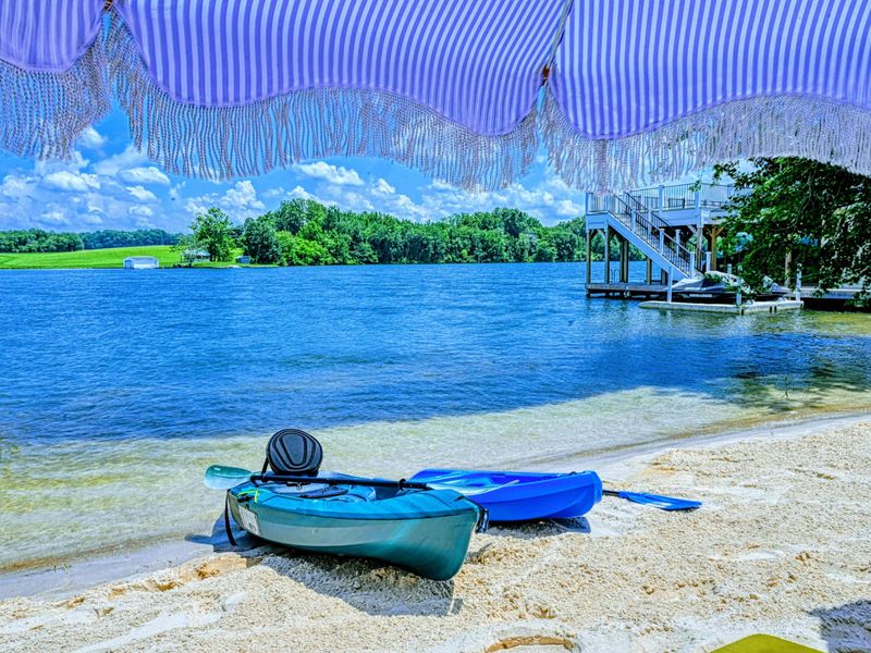 Beach Setup - Kayaks, shade, and a private sandy spot on the lake mean you can settle in for a full afternoon without packing a thing.