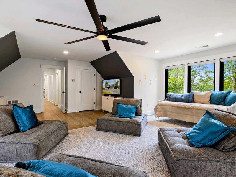 Bunk Room Loft - A large TV, modular loungers, and a daybed by the windows make this a perfect movie and game night space.