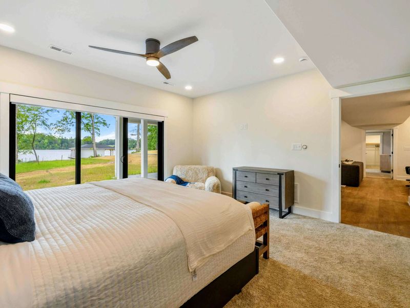 Bedroom 2 - The king suite opens directly to the lake-level patio, with an en-suite bathroom and reading chair for quiet mornings.
