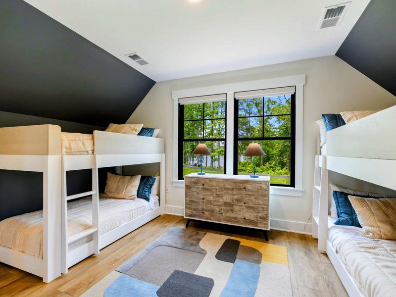 Bunk Room - A dresser and lamps between the bunk beds, with teal accent pillows adding a pop of color.