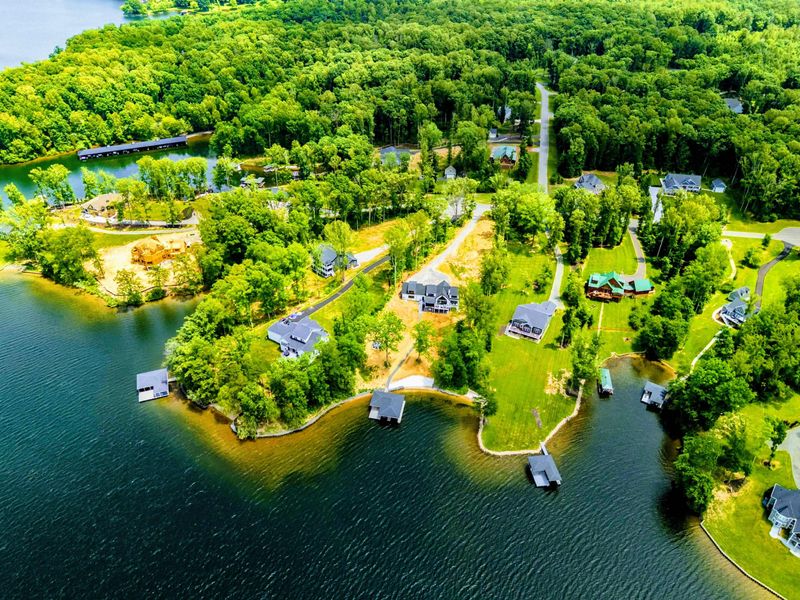 Aerial View - The lakefront neighborhood and surrounding waterways stretch out beneath a bright Virginia sky.