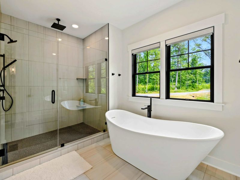 Primary Bathroom - The freestanding tub and oversized glass shower with dual showerheads make this a true spa retreat.